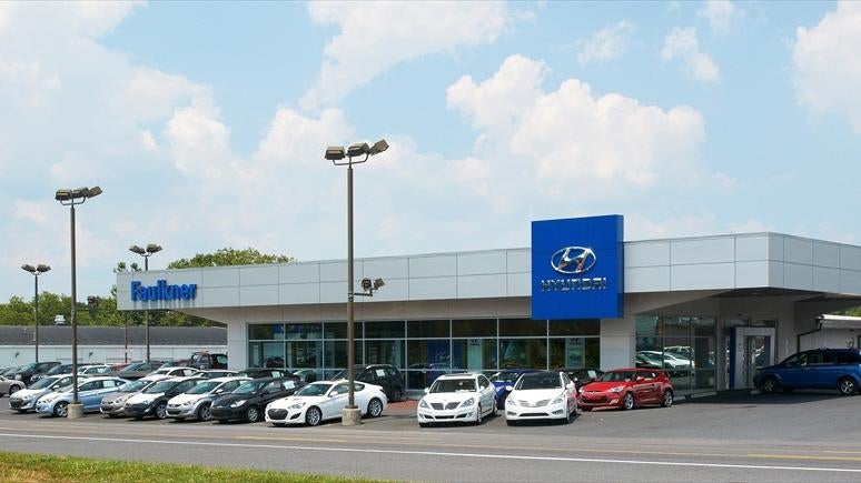 couple going over details of a new car with a sales rep at Faulkner Hyundai Harrisburg in Harrisburg PA 